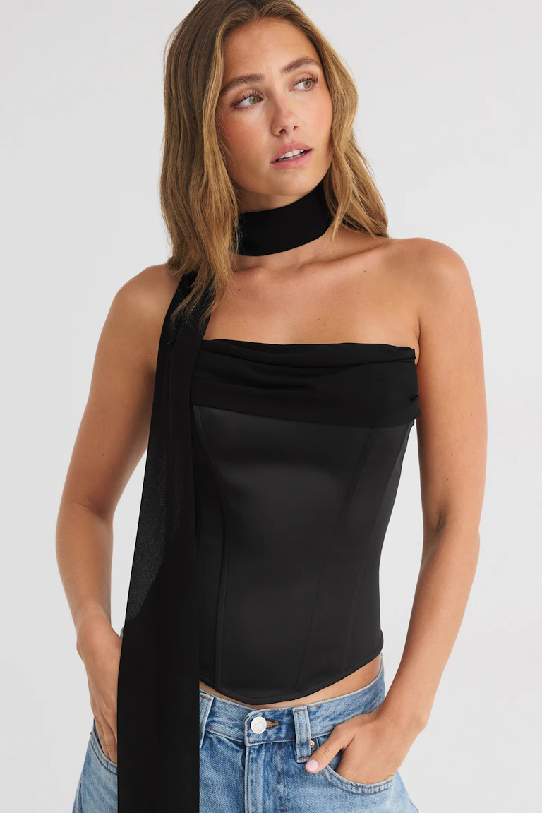 Black strapless top with a matching neck scarf, paired with blue jeans.
