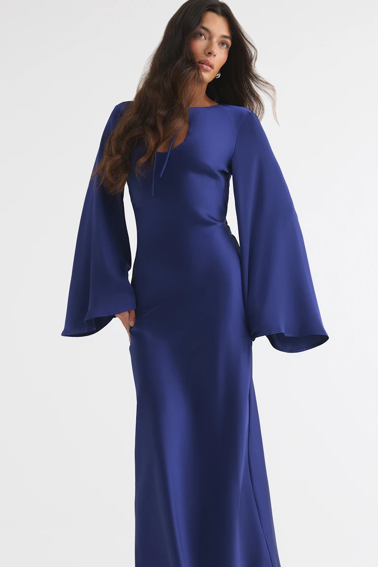 Floor-length cobalt blue dress with a fitted silhouette, wide bell sleeves, and a keyhole neckline.