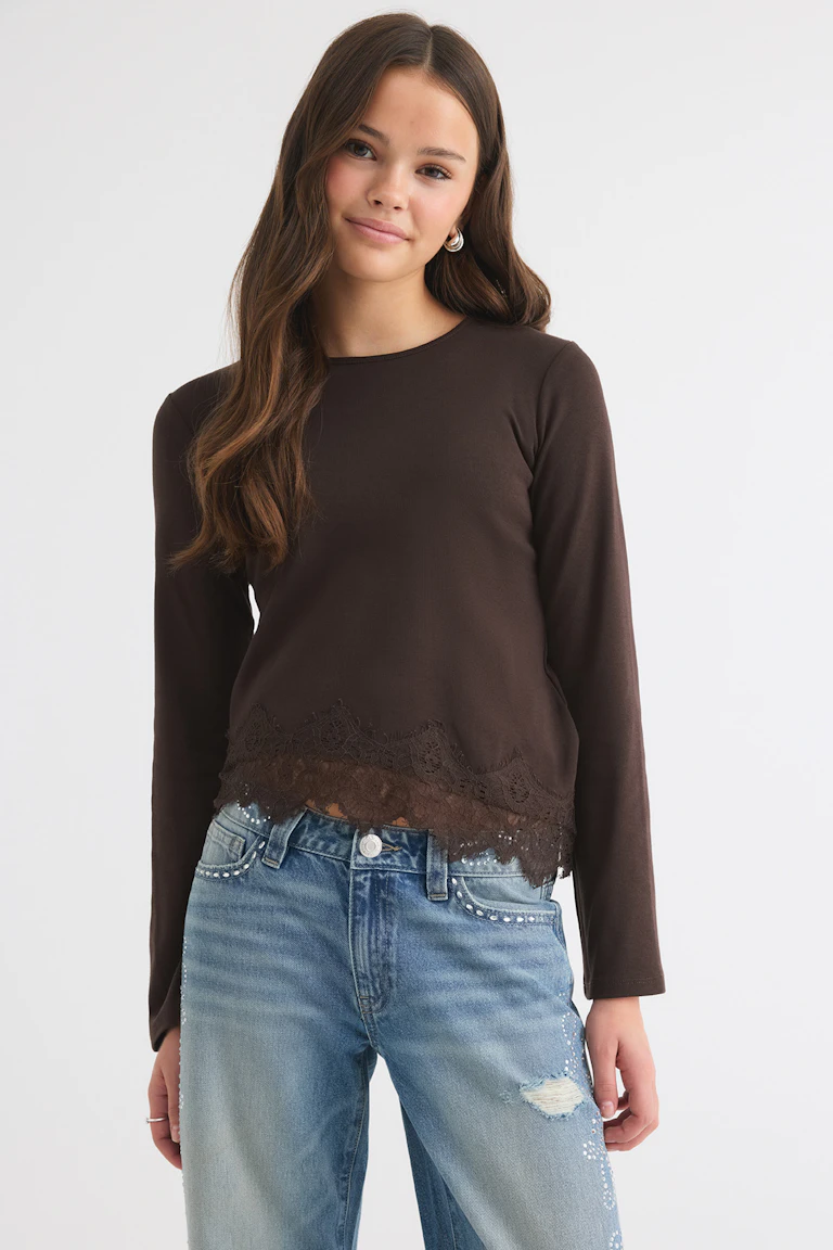 Dark brown long-sleeve top with lace hem, paired with light blue embellished jeans.
