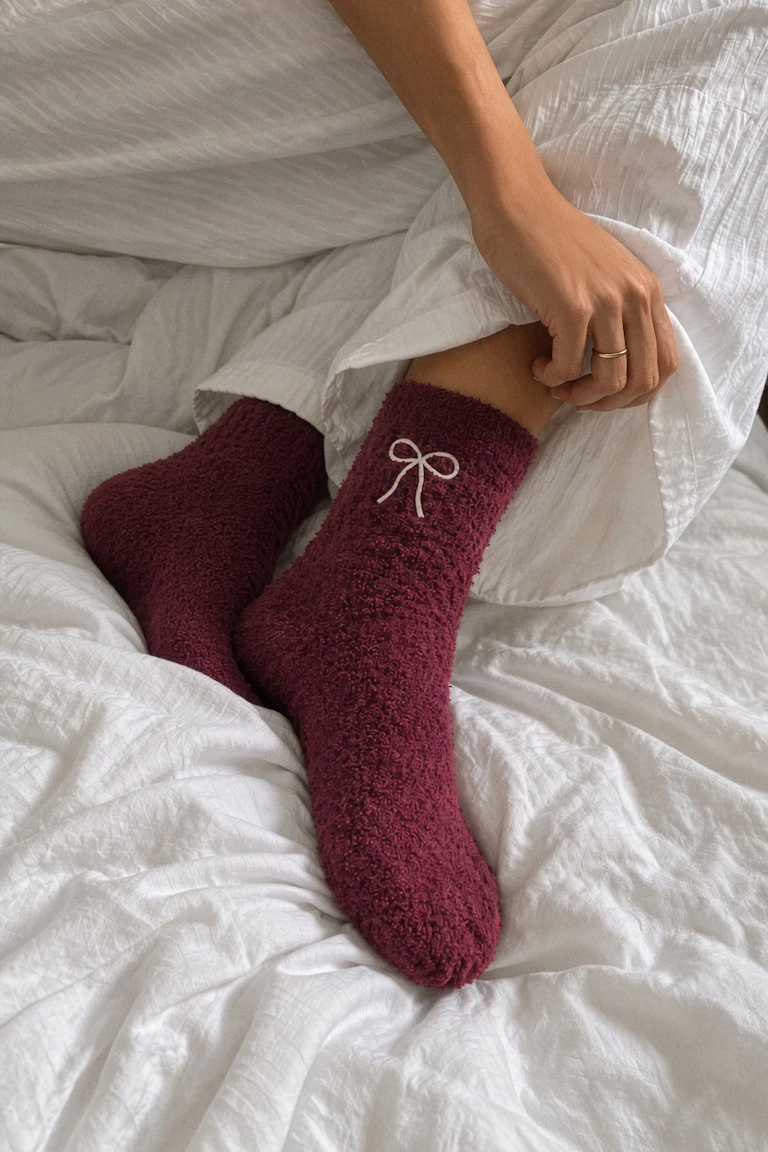 Weiße, gesteppte Loungewear mit burgunderroten, strukturierten Socken mit Schleifendetail.