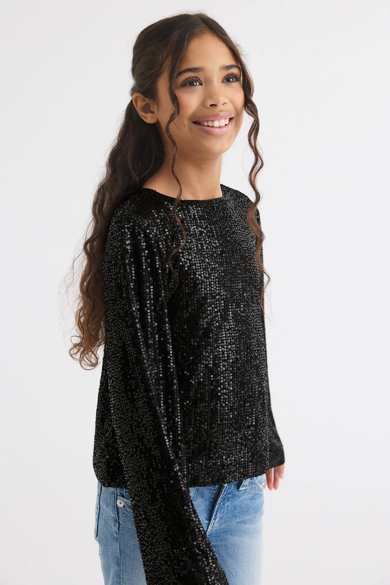 ID 341353, StyleColorSupplier 13018: black sequined long-sleeve top with light blue jeans.