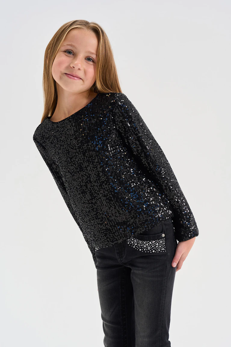 Black sequined long-sleeve top with black jeans featuring rhinestone detailing.