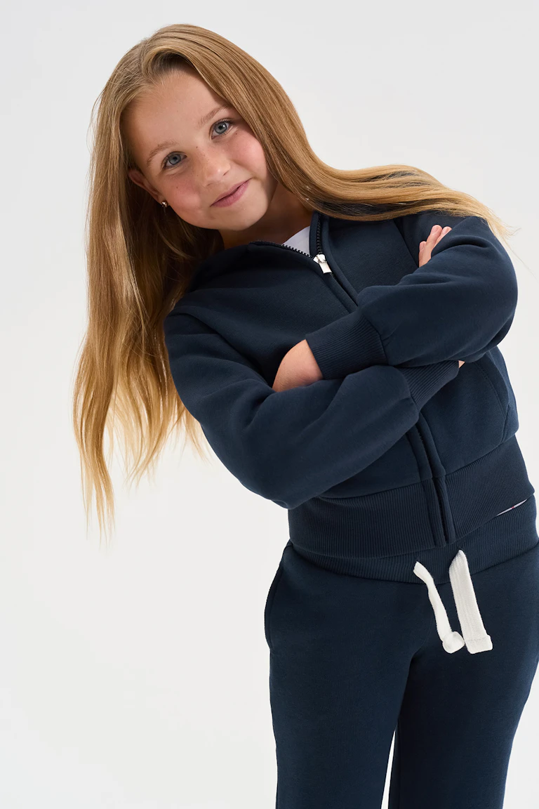 Navy zip-front hoodie and matching joggers with white drawstrings.