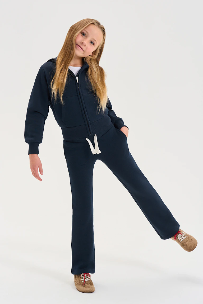 ID 356881, StyleColorSupplier 11519-E: navy zip-front hoodie and matching trousers, worn with a white top and tan sneakers.