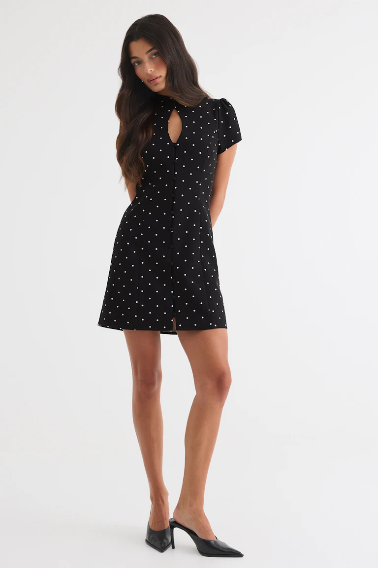 ID 342959, StyleColorSupplier 16657: Black polka-dot mini dress with short sleeves, a keyhole neckline, and black pointed-toe heeled mules.