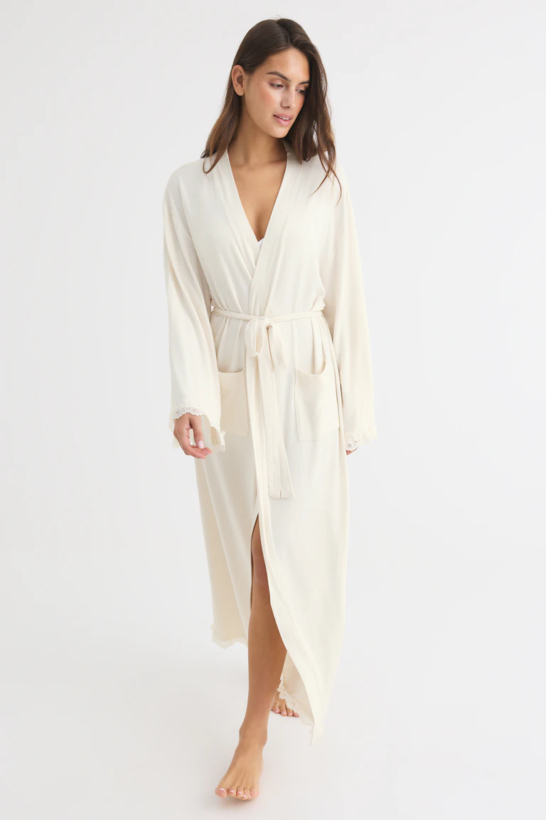 Cream wrap robe with tie waist, patch pockets, and lace-trimmed cuffs and hem.