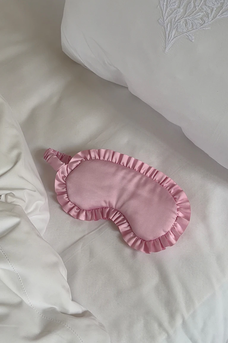 Roze satijnen oogmasker met gerimpelde rand.