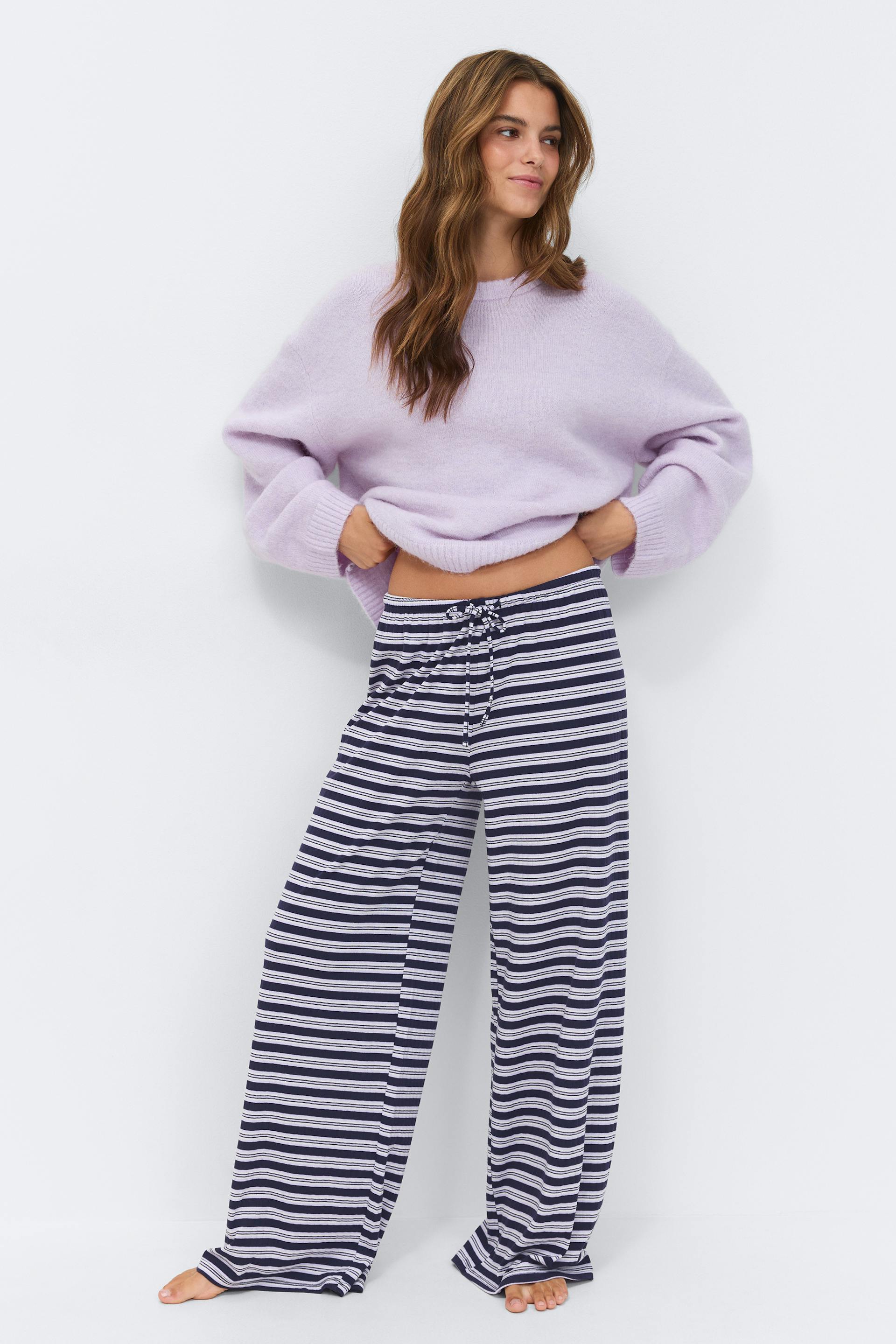 Lavendel oversized crewneck trui gecombineerd met marine-en-wit horizontaal gestreepte wijde-pijpen lounge broek met koord.